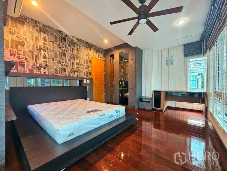 Detached House for rent in Chatuchak, Bangkok - Master bedroom view with feature wallpaper, built-in wardrobe and ceiling fan.