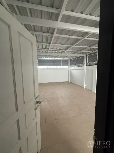 Shophouse for rent in Pak Kret, Nonthaburi - Covered rear terrace with tiled floor and metal roof structure.