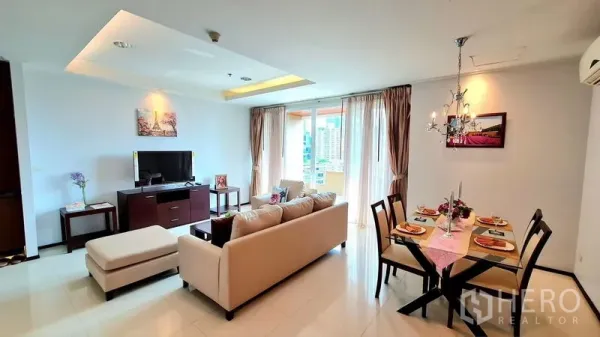 Apartment for rent in Watthana, Bangkok - Living and dining space opening to a balcony with city views near Phrom Phong BTS.