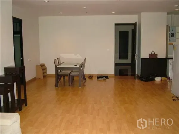 Condominium for rent in Khlong Toei, Bangkok - Spacious open-plan dining area with light wood flooring and a modern table in a Bangkok condo.