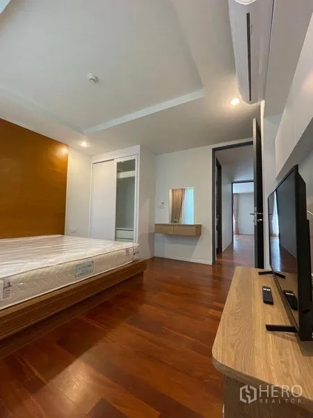 คอนโด ให้เช่าในWatthana, Bangkok - ห้องนอนพร้อมเตียง ตู้วางทีวี เครื่องปรับอากาศ และโต๊ะเครื่องแป้ง พื้นไม้