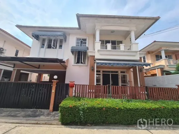 Detached House for rent in Sai Mai, Bangkok - Street view of the detached house facade with front hedge and gated fence.