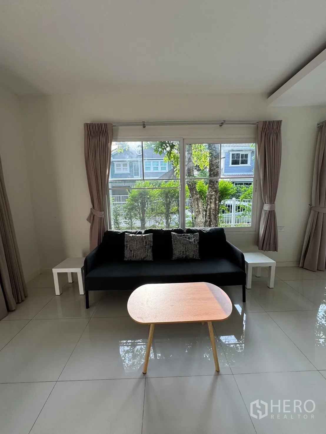 บ้านเดี่ยว for rent in Bang Phli, Samut Prakan - ห้องนั่งเล่นพร้อมโซฟา โต๊ะกลาง ผ้าม่าน และหน้าต่างวิวสวน