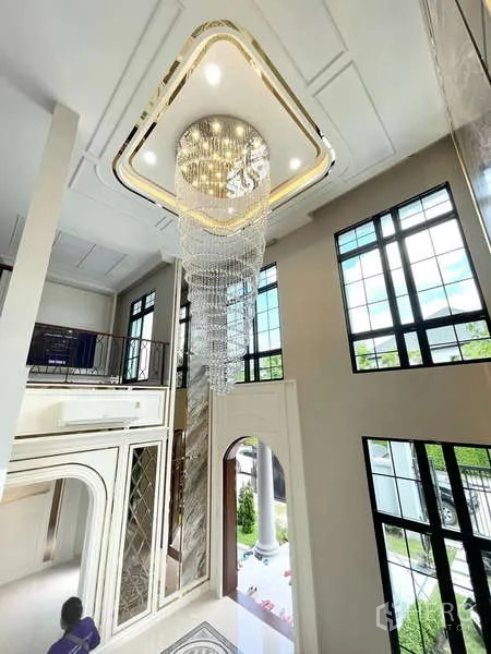 บ้าน ขายในThawi Watthana, Bangkok - โถงทางเข้าฝ้าเพดานสูงสองชั้น พร้อมหน้าต่างสูงและโคมไฟคริสตัล