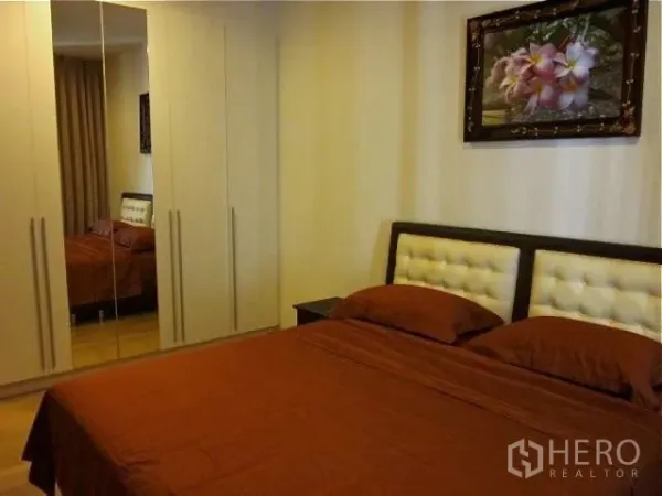 公寓 出租在Watthana, Bangkok - 卧室一角，带镜面嵌入式衣柜与软包床头。