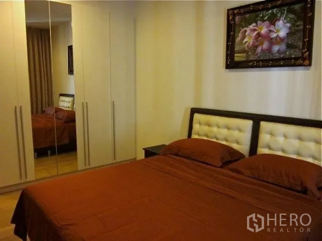 公寓 出租在Watthana, Bangkok - 卧室一角，带镜面嵌入式衣柜与软包床头。
