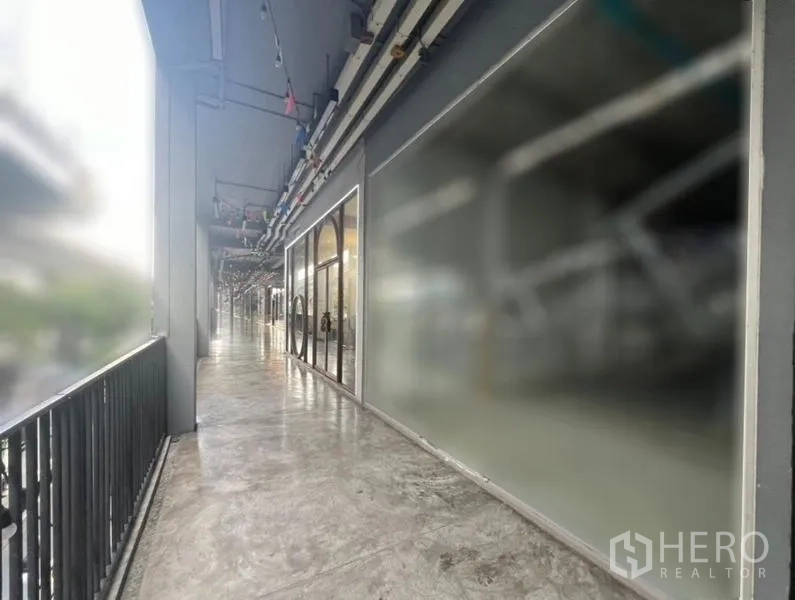 Retail Space for rent in Khlong Toei, Bangkok - Open-air corridor with shopfronts and railing outside the unit.