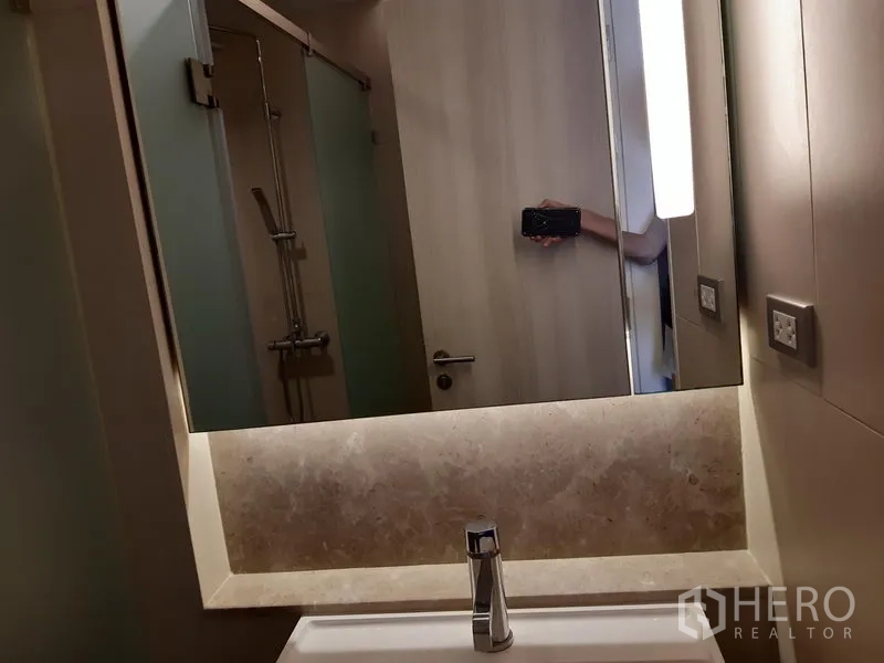 Condominium for rent in Khlong Toei, Bangkok - Shower room with illuminated mirror above the vanity.