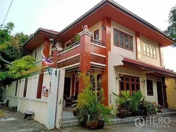 บ้าน ขายในBang Na, Bangkok - ภายนอกบ้านเดี่ยวสองชั้น มีระเบียง แต่งอิฐสีแดง และต้นไม้กระถาง