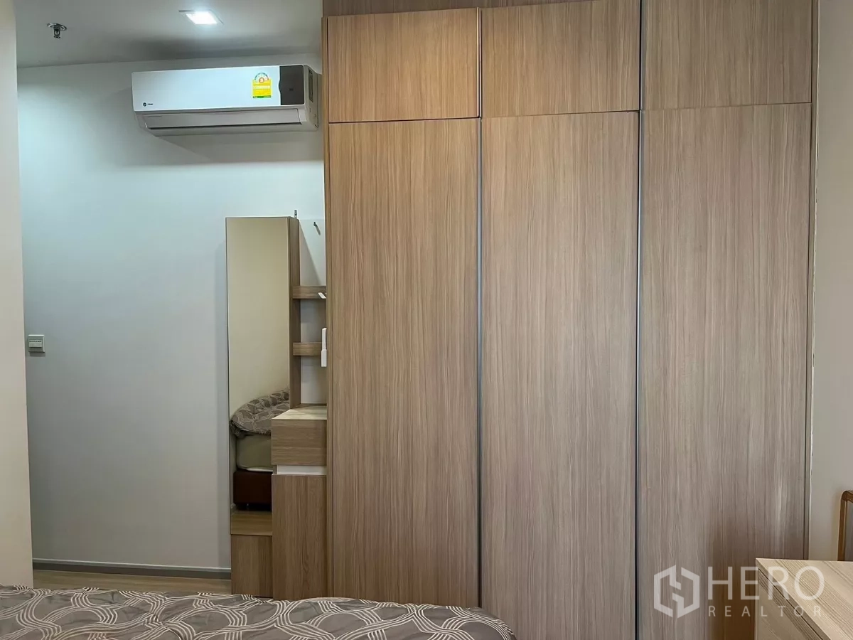 Condominium for rent or sale in Chatuchak, Bangkok - Bedroom wall featuring a large built‑in wardrobe and an air‑conditioning unit.