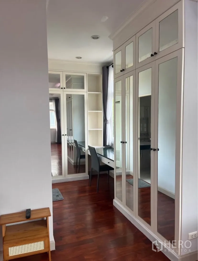 Detached House for rent or sale in Lat Phrao, Bangkok - Walk-in closet area with mirrored wardrobes and a built-in dressing desk.