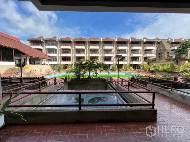 Townhouse for rent or sale in Suan Luang, Bangkok - Community courtyard in the townhouse compound with greenery and a long swimming pool.