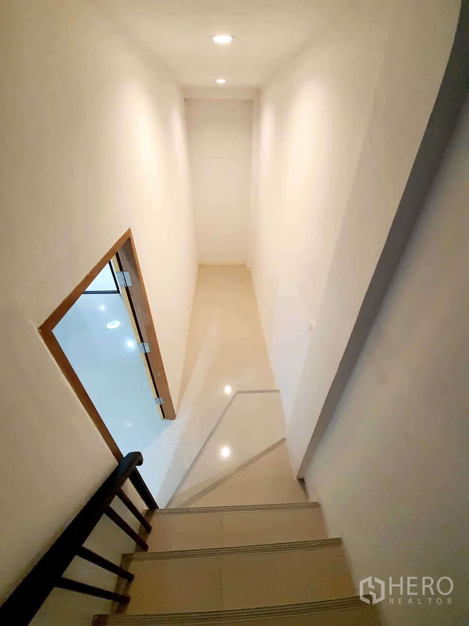 带办公室的家 出租在Khlong Toei, Bangkok - 从楼梯向下看，通往玻璃门与瓷砖走廊的视角。