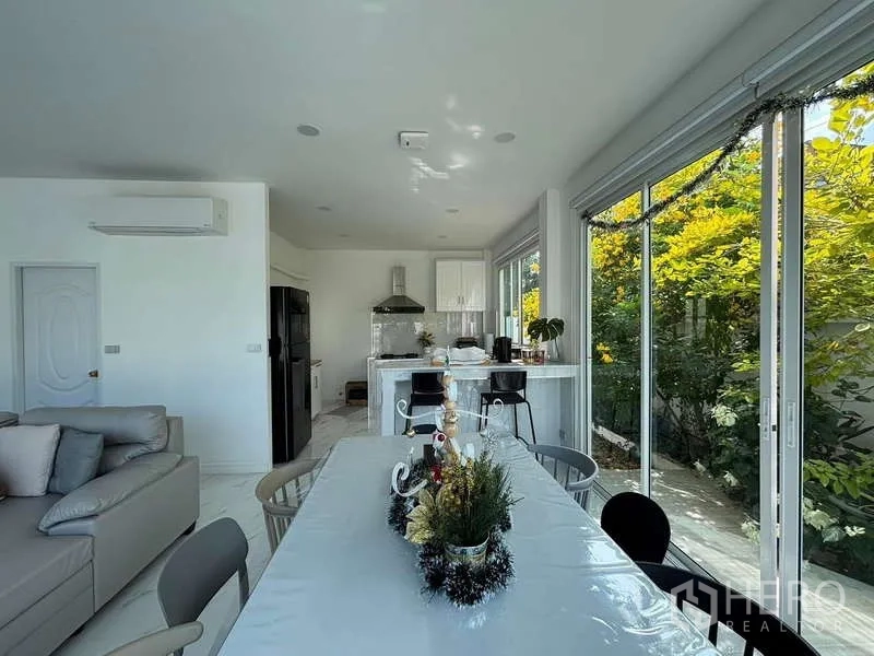 Detached House for rent in Lat Krabang, Bangkok - Open dining and kitchen zone with bar seating and leafy garden outlook.