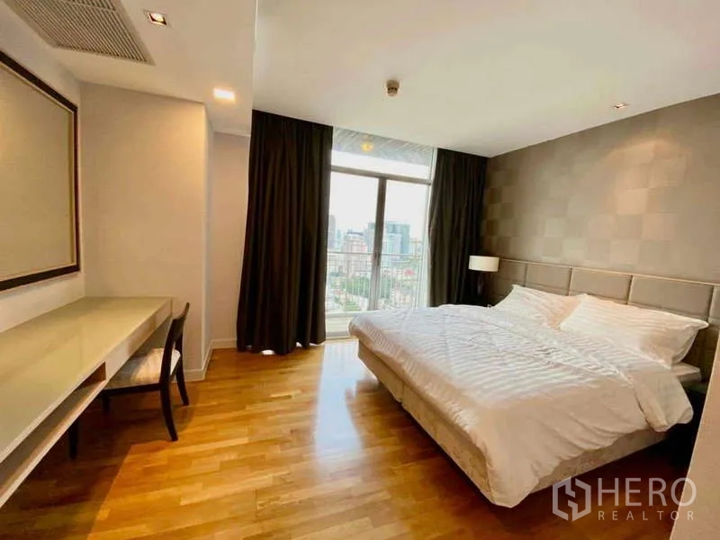 Condominium for rent or sale in Sathon, Bangkok - Second bedroom with king bed, study desk, and window facing the skyline.