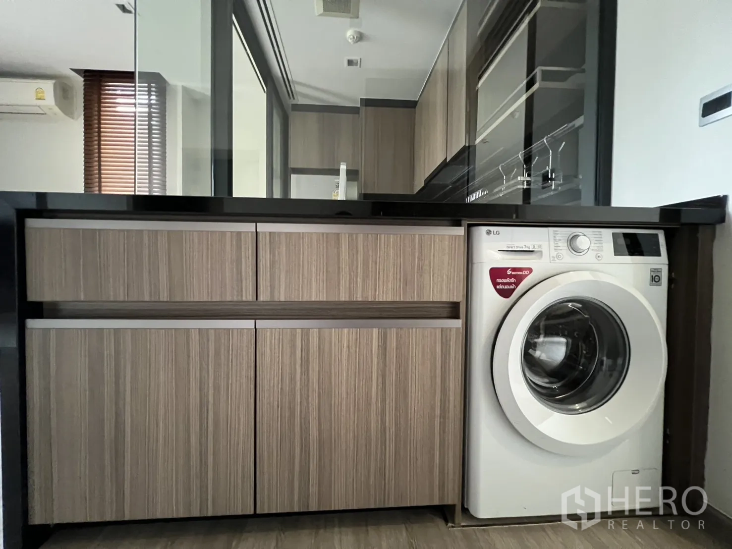 คอนโด for rent in Watthana, Bangkok - เคาน์เตอร์ครัวท็อปหินสีดำพร้อมตู้ล่างไม้และเครื่องซักผ้าฝาหน้า