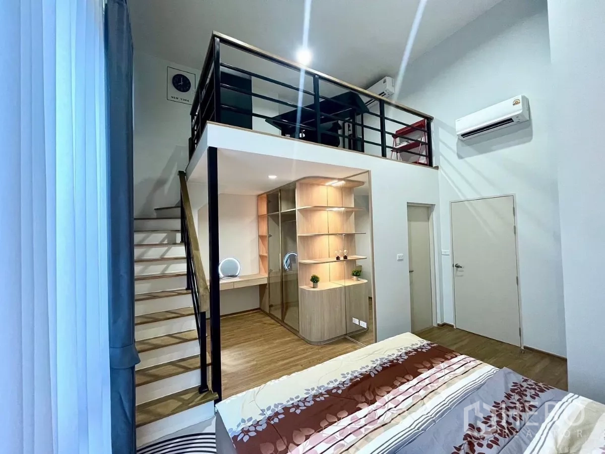 Townhouse for rent in Samut Prakan - Master bedroom with high ceiling, glass wardrobe and loft workspace.