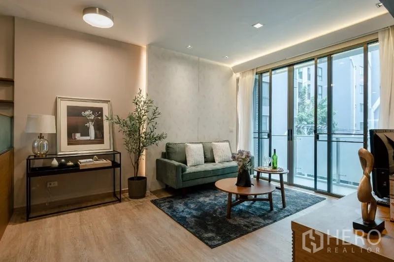 Condominium for sale - Living room angle showing sofa, side console and floor-to-ceiling windows.