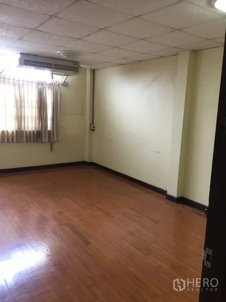 联排别墅 出租在Khlong Toei, Bangkok - 木地板卧室，窗机空调与窗帘