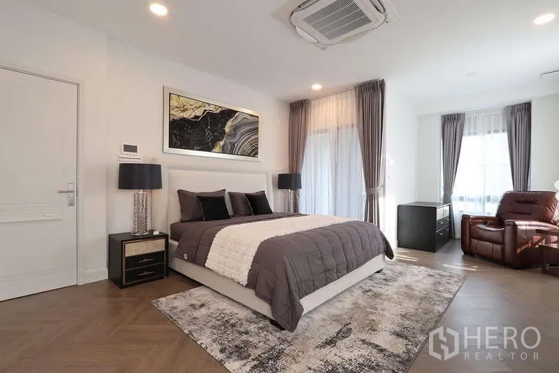 Detached House for rent in Saphan Sung, Bangkok - Grand master bedroom with king bed, recliner chair and large TV console.