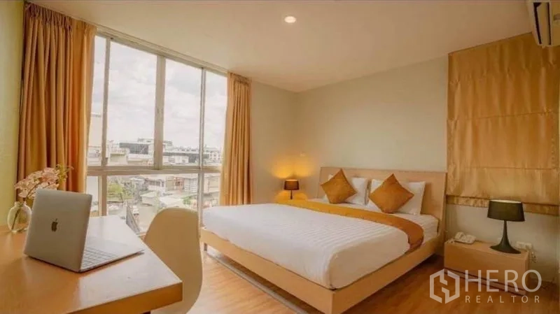 Retail Space for sale in Phra Nakhon, Bangkok - Bedroom with city view through wide window, minimalist decor and work desk.