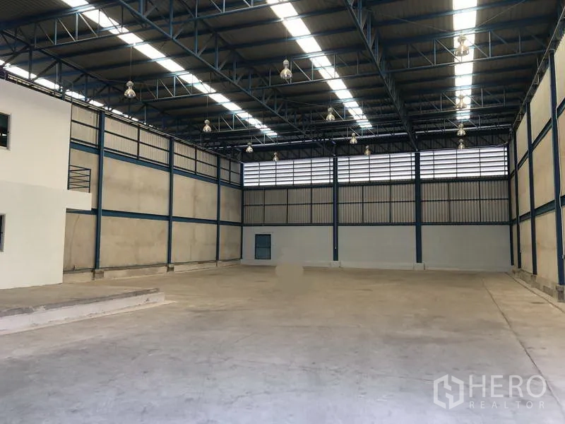 Warehouse for rent in Bang Phli, Samut Prakan - Open storage hall with high‑bay lighting, ventilation louvers and wide column‑free span.