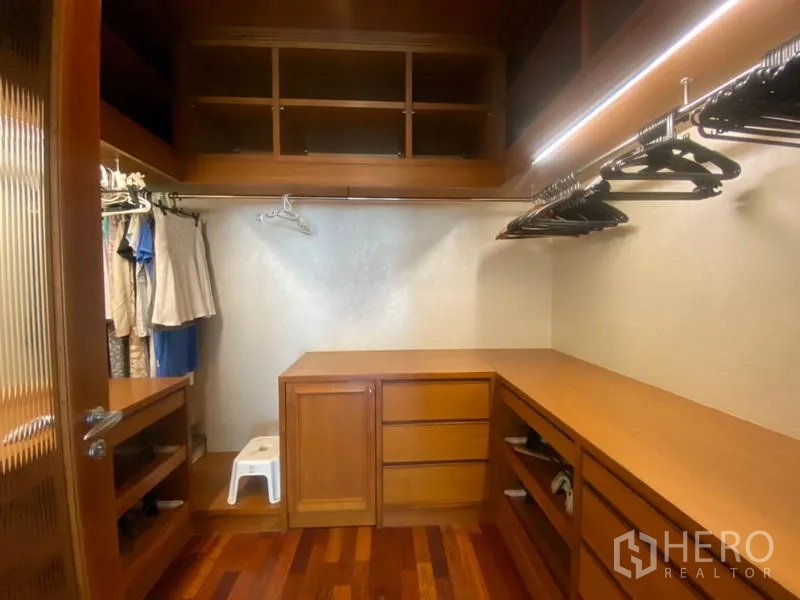 Condominium for rent in Sathon, Bangkok - Walk-in closet featuring built-in wooden shelves, drawers and ample hanging space.