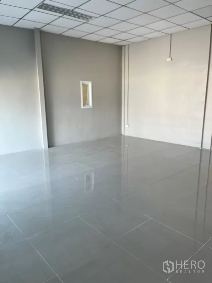 Warehouse for rent in Lat Lum Kaeo, Pathum Thani - Another angle of the tiled office with a small window and grid ceiling.
