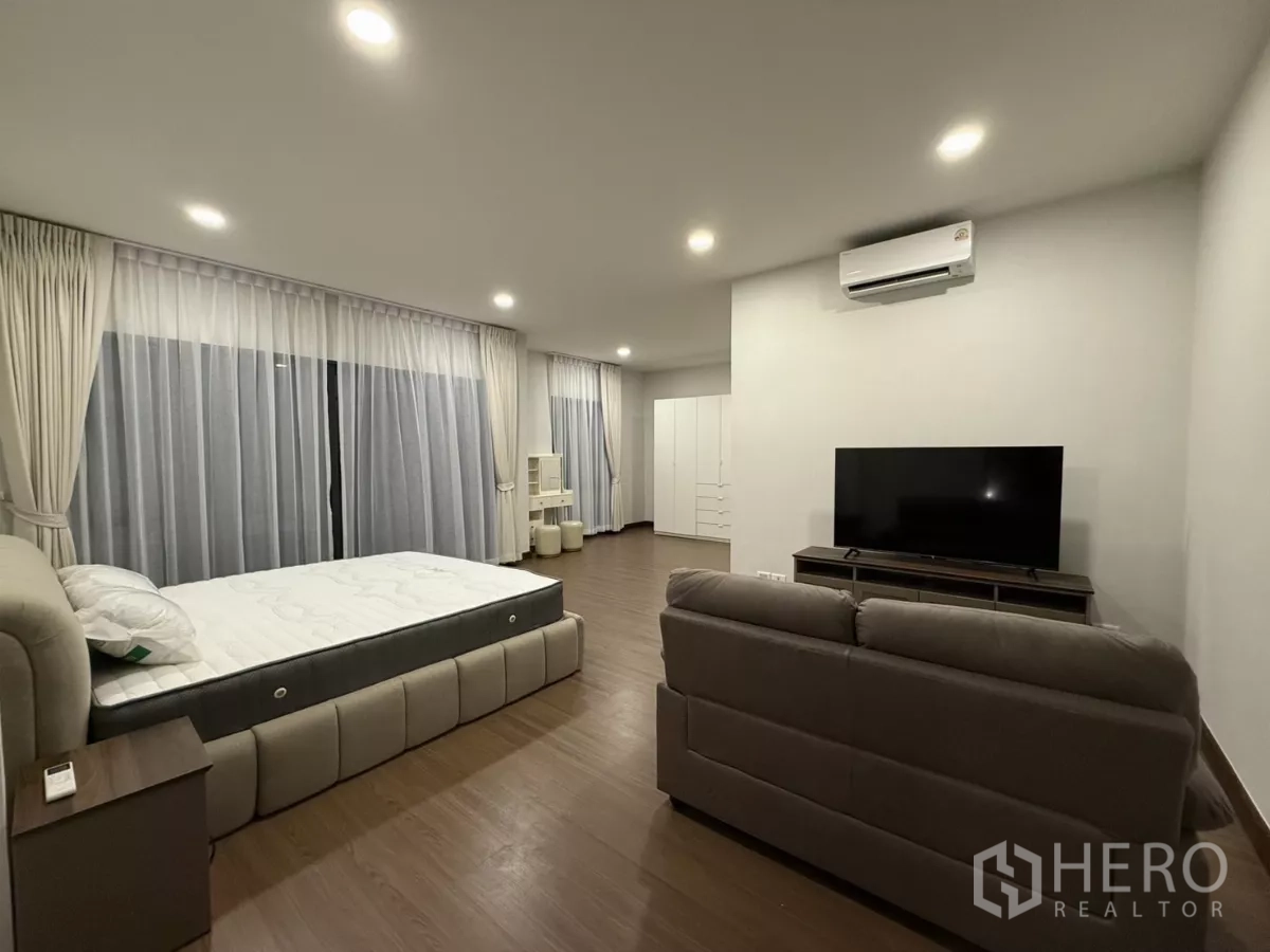 独立式住宅 出租在Bang Phli, Samut Prakan - 主卧角度，电视柜、空调与整面窗帘。