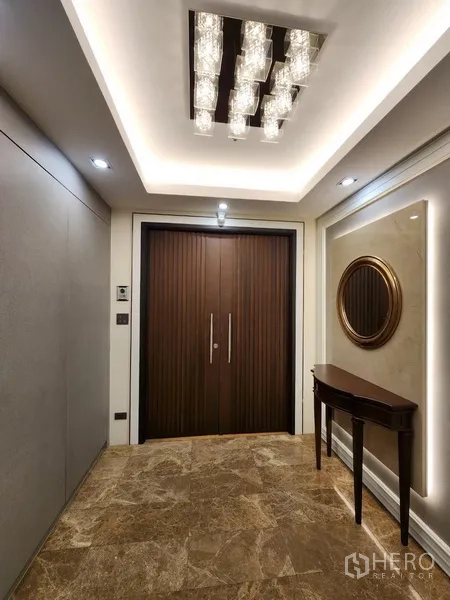 Condominium for rent in Khlong Toei, Bangkok - Private lift lobby with double wooden entry doors and chandelier.