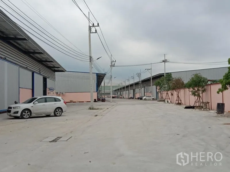 โรงงาน ให้เช่าในBan Phaeo, Samut Sakhon - ด้านหน้าอาคารโรงงาน ประตูเหล็กบานเลื่อน กันสาด และระบบไฟฟ้าแรงสูงสามเฟส