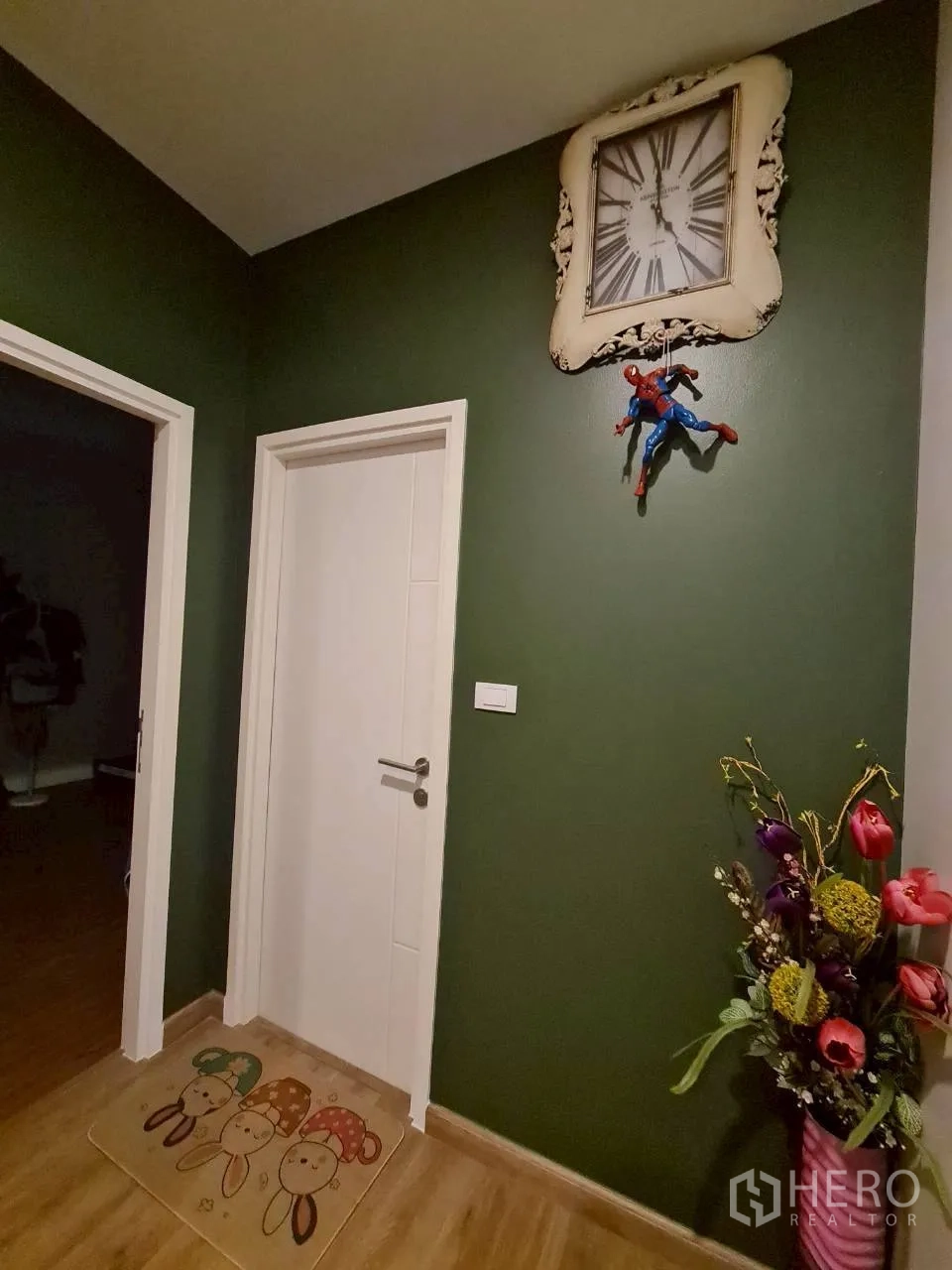 Detached House for rent or sale in Lam Luk Ka, Pathum Thani - Hallway corner with a green accent wall, white door and decorative clock.