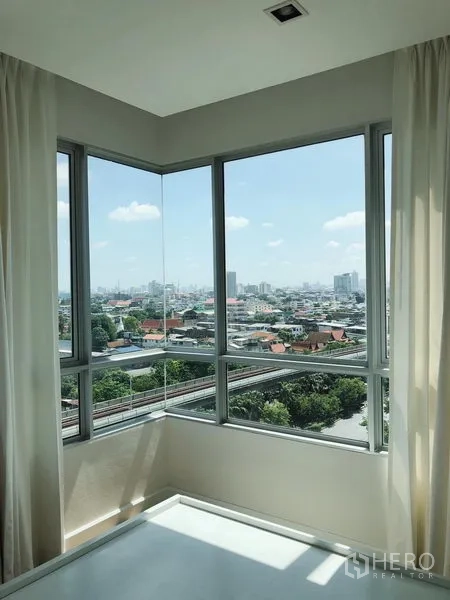 Condominium for rent in Bang Rak, Bangkok - Corner windows showcasing panoramic Bangkok city view and sky rail line.