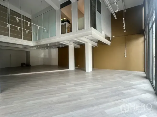Retail Space for rent in Khlong Toei, Bangkok - Open-plan showroom featuring a mezzanine level with glass panels and track lighting.