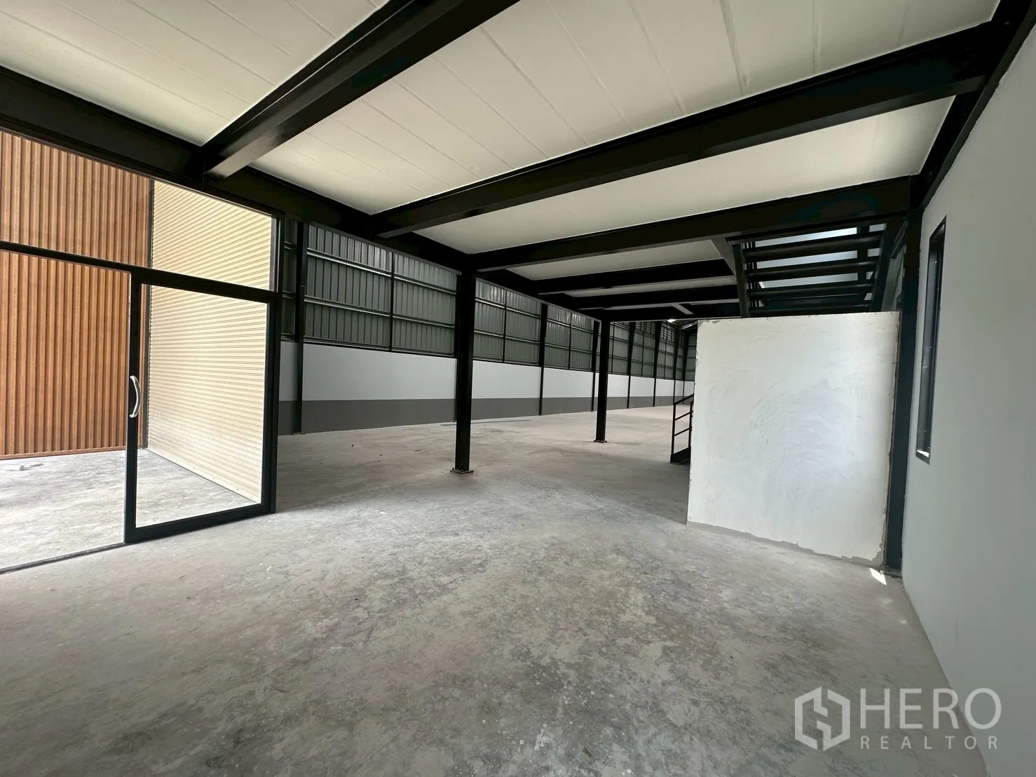 Warehouse for rent in Suan Luang, Bangkok - Open-plan ground floor with glass entry and mezzanine structure inside the warehouse.