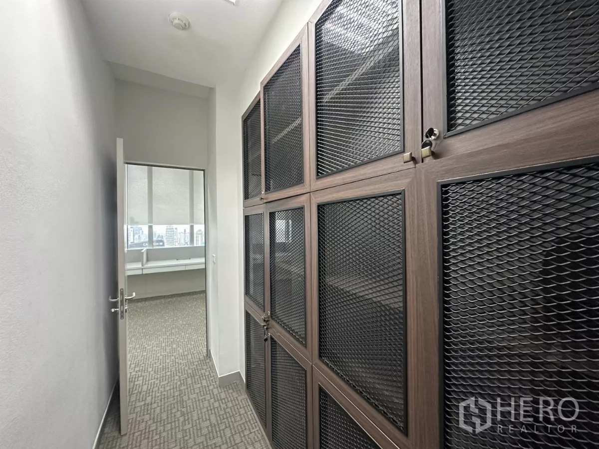 Office Space for rent in Watthana, Bangkok - Secure storage area with metal-mesh lockers next to the workspace.
