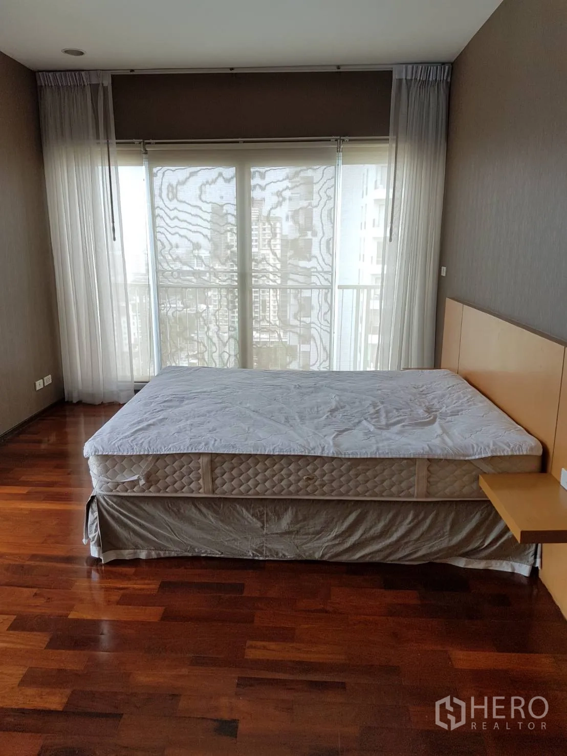 公寓 出租或出售在Watthana, Bangkok - 卧室面向整面落地窗和城市景观阳台，通铺木地板