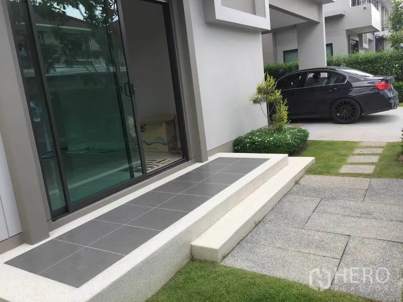 独立式住宅 出售在Pak Kret, Nonthaburi - 前庭台阶与推拉落地门，旁有车道与灌木