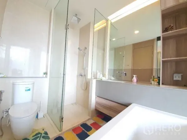 公寓 出租或出售在Watthana, Bangkok - 现代浴室，玻璃淋浴间、顶喷花洒与大镜面洗手台，色调素雅。