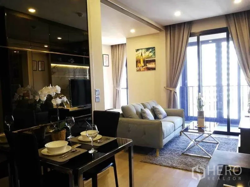 Condominium for rent in Watthana, Bangkok - Two-seat dining nook beside the open living room with floor-to-ceiling windows and balcony access.