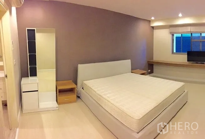 公寓 出租在Watthana, Bangkok - 主卧另一角度，展示床、床头柜与收纳柜。