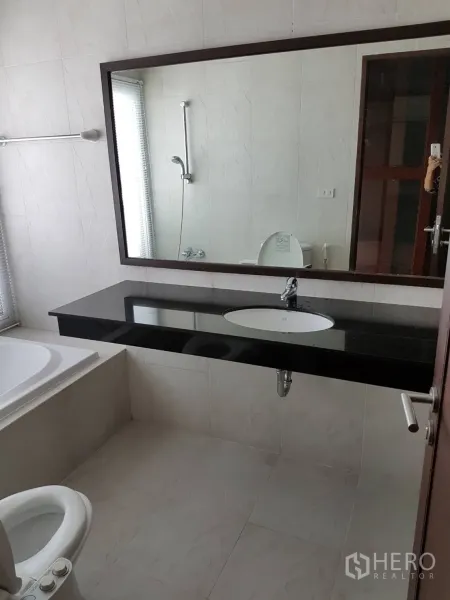 公寓 出租或出售在Watthana, Bangkok - 明亮浴室配大镜子、黑色石材台面、浴缸与坐便器