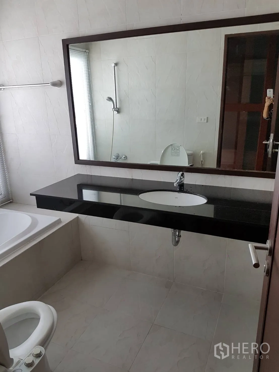公寓 出租或出售在Watthana, Bangkok - 明亮浴室配大镜子、黑色石材台面、浴缸与坐便器