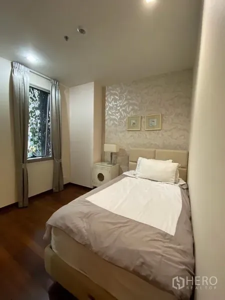 Condominium for rent in Khlong Toei, Bangkok - Second bedroom with single bed, patterned feature wall and soft natural light.