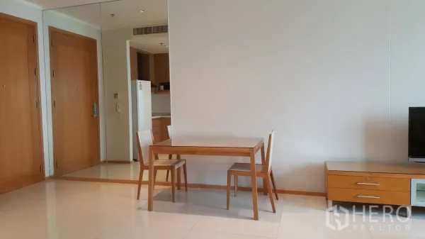 公寓 出租在Khlong Toei, Bangkok - 开放式客餐厅，餐桌椅、电视柜、镜面墙与亮面瓷砖地面。