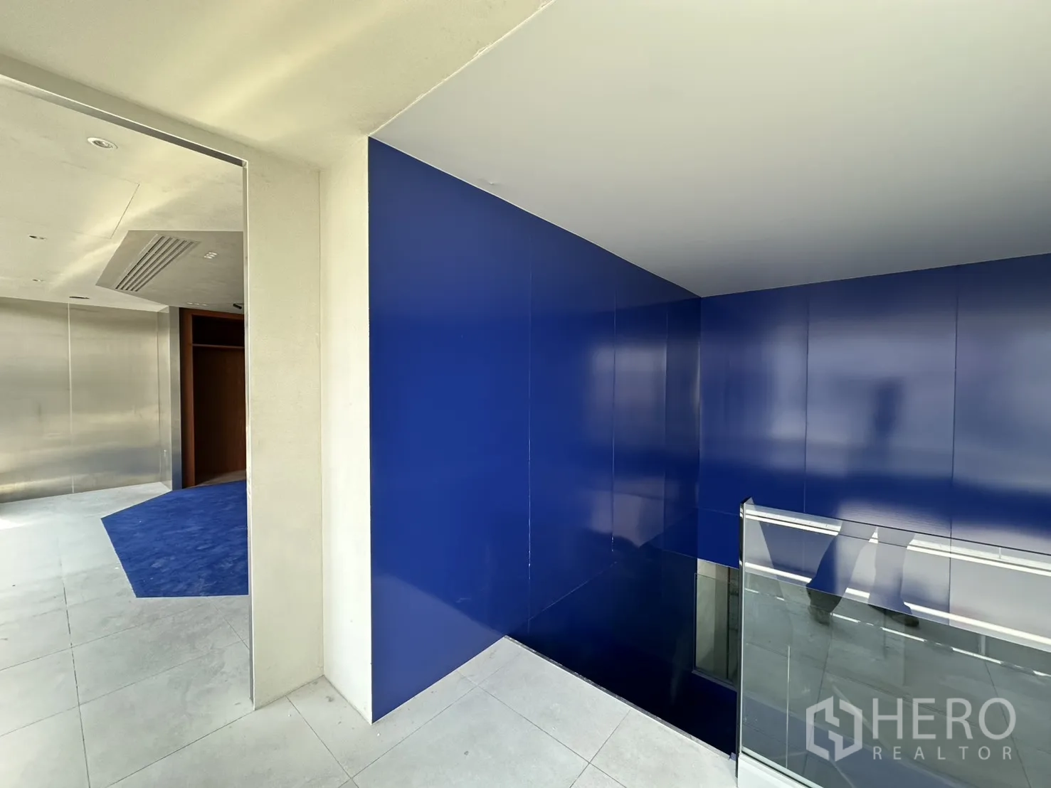 พื้นที่ขายของ for rent in Watthana, Bangkok - โถงบันไดกรุแผงสีน้ำเงินเงาพร้อมราวกันตกกระจก.