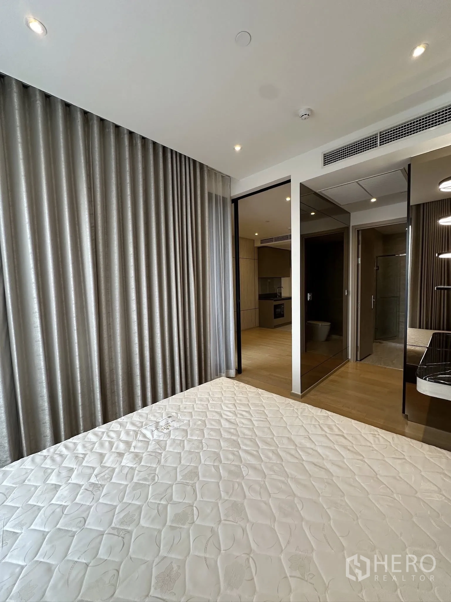 Condominium for sale in Din Daeng, Bangkok - Bedroom view with full-length curtains, sliding glass door to living area, and mirrored closet.