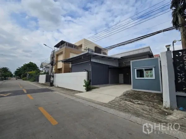 货栈 出租在Don Mueang, Bangkok - 斜角视图，展示宽阔道路与通往卷闸门的混凝土车道。