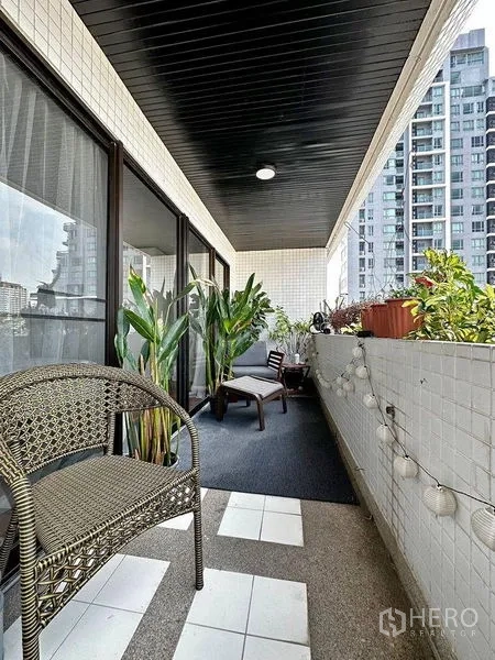 公寓 出租在Watthana, Bangkok - 带顶阳台，绿植与休闲座椅，可见素坤逸高楼景色。