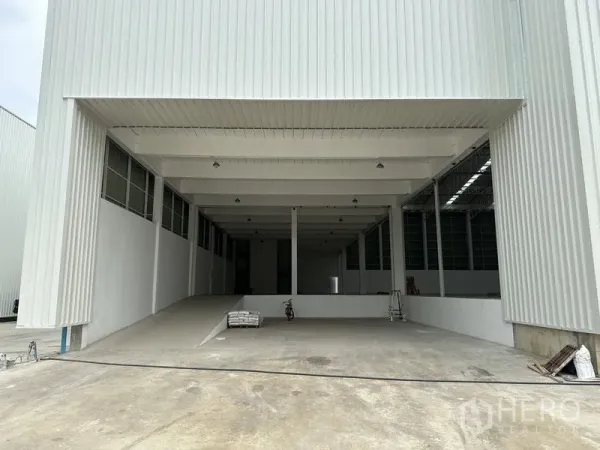 工厂 出租在Pathum Thani - 带顶装卸区与坡道，通向仓库内部。